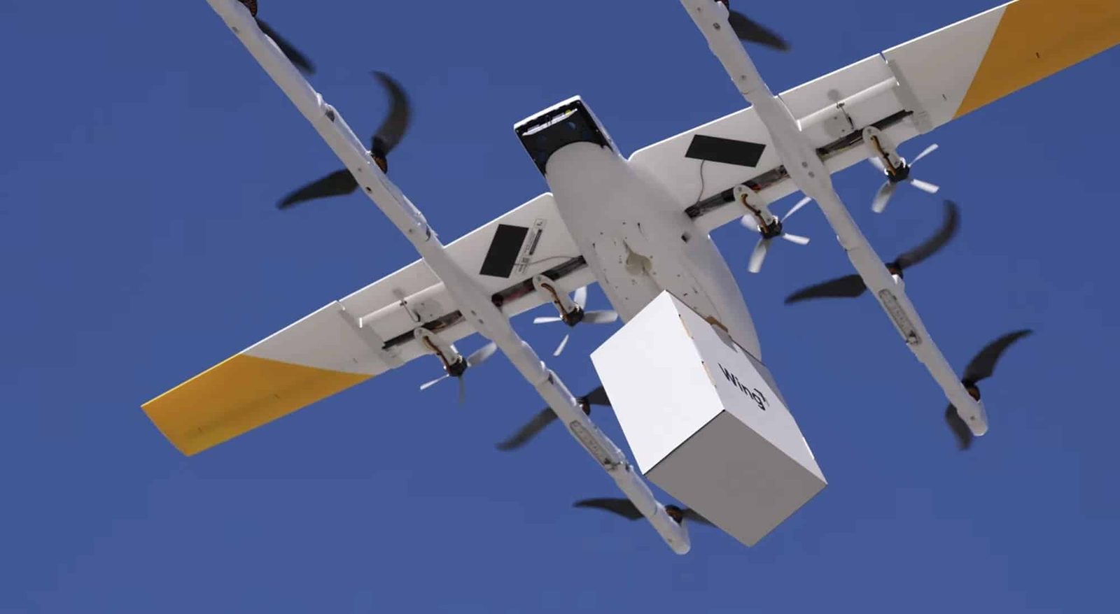 A Wing delivery drone carrying a package. Belvedere's ordinance would regulate where the drop can happen, not the flight above it; no company has proposed drone service in the city.